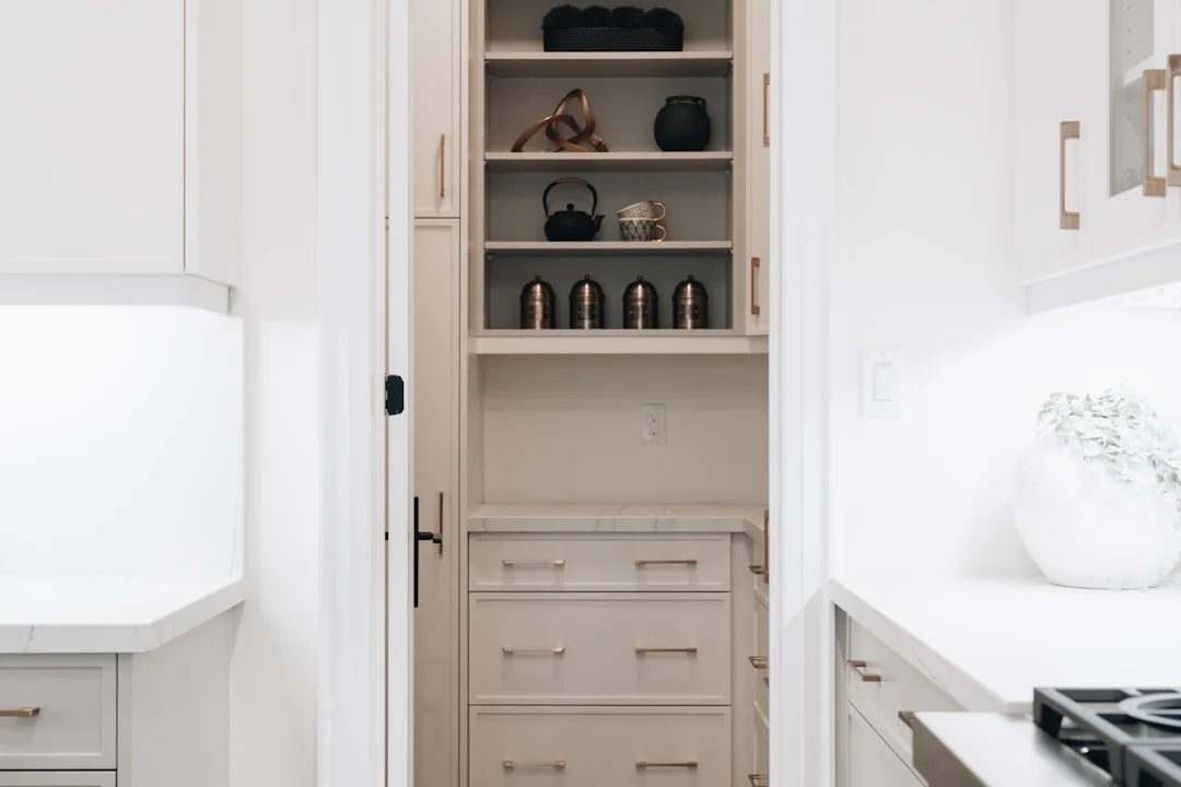 Une femme de chambre professionnelle rangeant des coussins dans une chambre d’hôtel luxueuse, tout en veillant à la qualité du service.